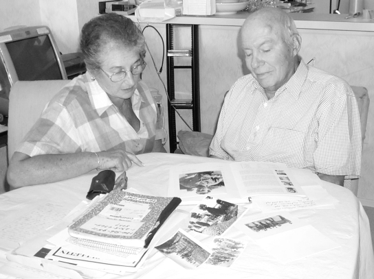 Harry Glixon and his wife, Lorraine, look at the book he wrote for his grandchildren and some old war pictures involving his time as a POW of the Germans during World War II.