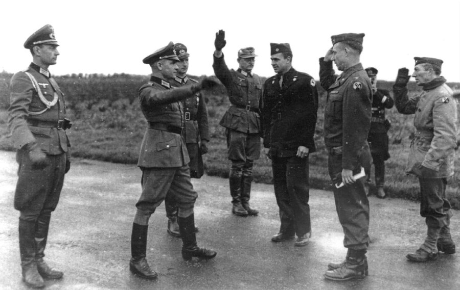 The officer giving the Hitler salute in the foreground was in charge of the POW exchange for the Germans. Andrew Gerow Hodges, the American Red Cross representative in the dark uniform in the center, set up the prisoner exchange in Brittany in November 1944. Pvt. Harry Glixon of Sarasota, Fla. was a member of the 301st Infantry Regiment, 94th Division of the 3rd Army who was exchanged by the enemy.  