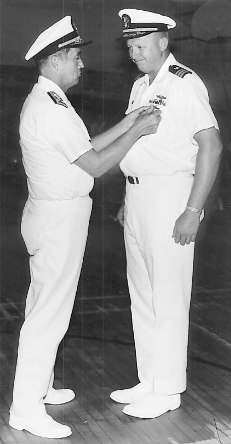 Adm. Dennis Wilkinson pins the Distinguished Service Medal on Mack for trailing a Russian sub underwater for 47 days. This is the highest peace-time commendation awarded a military officer. It’s normally reserved for admirals.