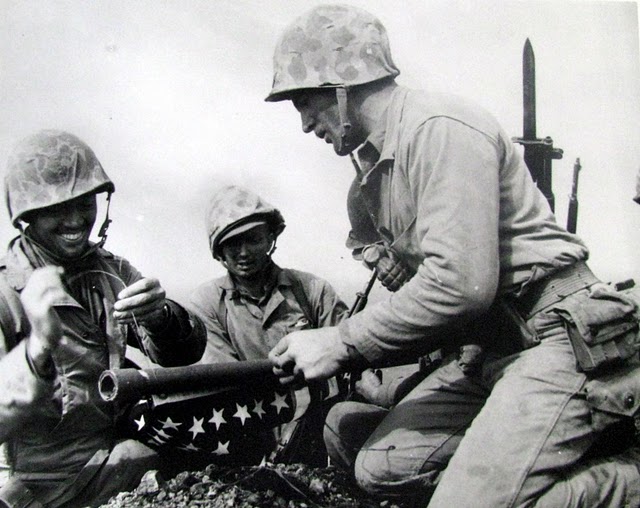 Three of the Marines involved in putting up the first American flag on Suribachi get it ready to fly. Tying the line to the flagpole is Lt. Harold Schrier, Sgt.Ernest Thomas is in the middle, and Cpl. Charles Lindberg on the right. Photo provided by Dick Honyak