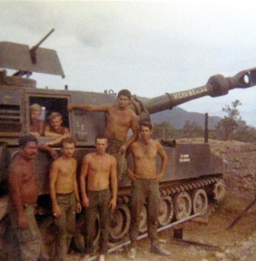 This is what a 155 millimeter gun crew looks like. The crew is standing in front of their artillery piece. Photo provided