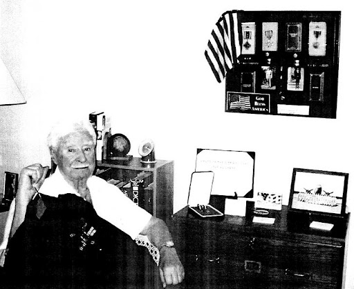 Thomas Lemery holds his dress uniform with silver wings and campaign ribbons. On the wall in his Port Charlotte home is a shadow box containing his military decorations and other service memorabilia he collected over the years cover the cabinet below. Sun photo by Don Moore