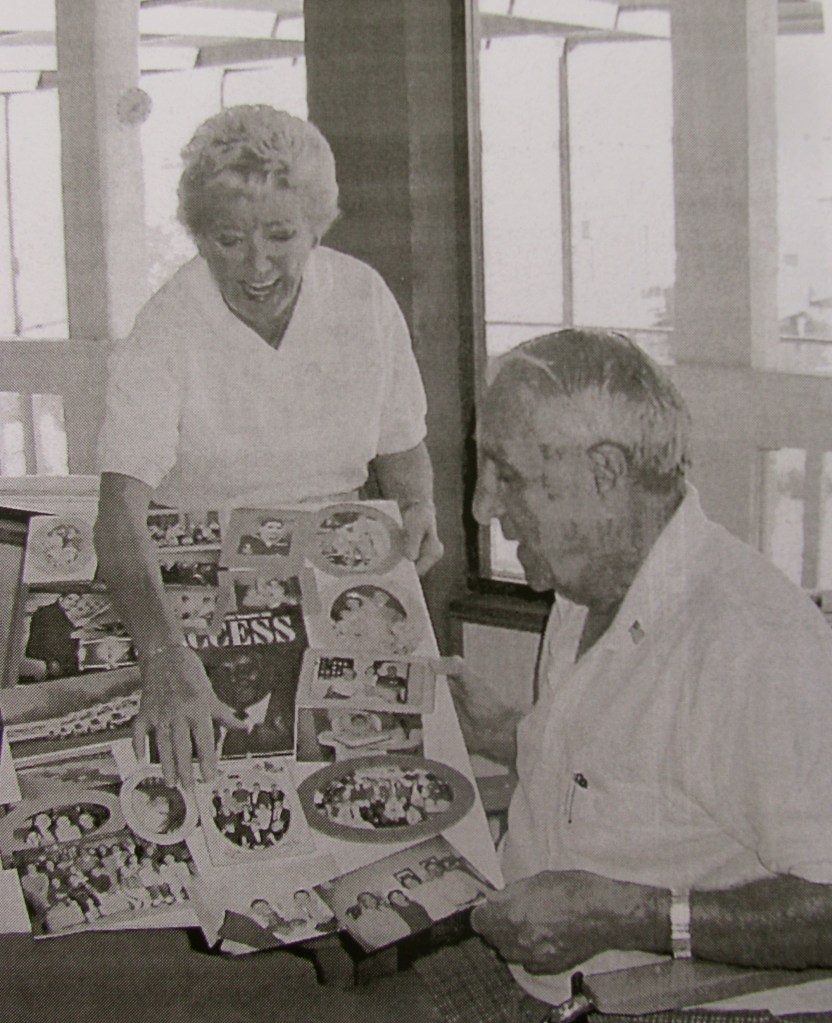 Hazel Nicholas shows her husband, Art, a poster she is making to commemorate his life. It's for his 80th birthday which is Feb. 15. He was a "frogman" and boatswain's mate in the Navy in World War II. Sun photo by Don Moore