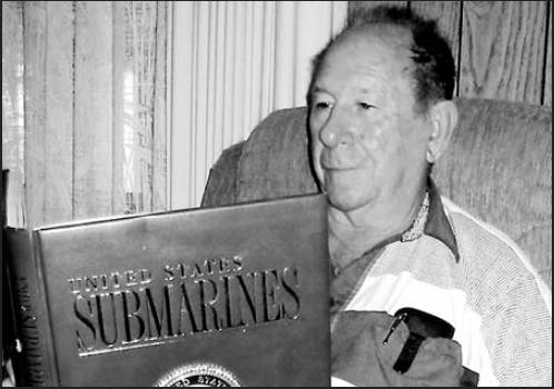 Former submariner Jerry Bauer of Village of Holiday Lakes mobile home park looks at a copy of "United States Submarines" that contains pictures of many of the subs he served on during the "Cold War."