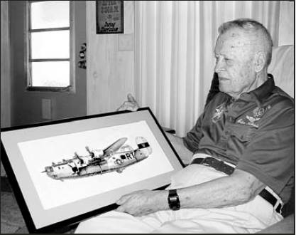 Former 1st Lt. Adam Kubinciak, who lives in La Casa mobile home park in North Port, holds a picture of his B-24 "Liberator" "Miss Liberty," that he flew during World War II. The picture of the plane was cross-stitched by Pat Pocock of Bungay, England, near where Kubinciak's bomber group was stationed.
