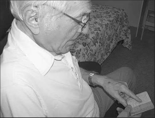 Don Smally looks at a tiny notebook in which he kept track of all the places he travelled and what he saw while serving in Europe during World War II. Sun photo by Don Moore