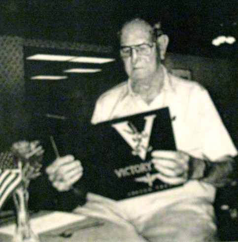 Former Air Force Lieutenant Guice Johnson of Royal Palm Retirement Center in Port Charlotte, Fla. looks at a book about the Aviation Cadet Program in Texas. He graduated from the program during the second World War. Sun photo by Don Moore