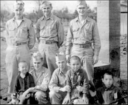 Bond is the soldier squatting at the left, holding onto a pint-sized kid. Photo provided