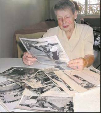 Winifred looks at magazines and other memorabilia from a lifetime ago when she was a poster girl for the WACs in World War II. Sun photo by Don Moore