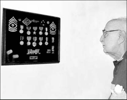 Vincent Carvalho of Rotonda looks at a shadowbox full of medals he received while serving in the Americal Division in the Pacific during World War II. 