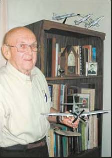 Col. Hal Johnson, who lives in southwest Florida, holds a model of an A-1 attack bomber like the one he flew in Vietnam. Sun photo by Don Moore