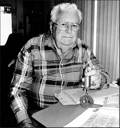 Wilbur Kinney of Port Charlotte, Fla., who served aboard three aircraft carriers during World War II, holds a commemorative medallion he received from the Commonwealth of the Northern Marinas for his service in the war. Sun photo by Don Moore