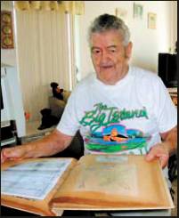 Al Bond looks at a scrapbook his wife kept about his unit, the 11th Airborne Division, called “The Angels,” during World War II.  Sun photo by Don Moore