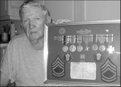    George Phillips of North Port is pictured with a shadow box full of his World War II medals and his sergeant stripes. He served in Gen. George Patton’s 3rd Army. Sun photo by Don Moore