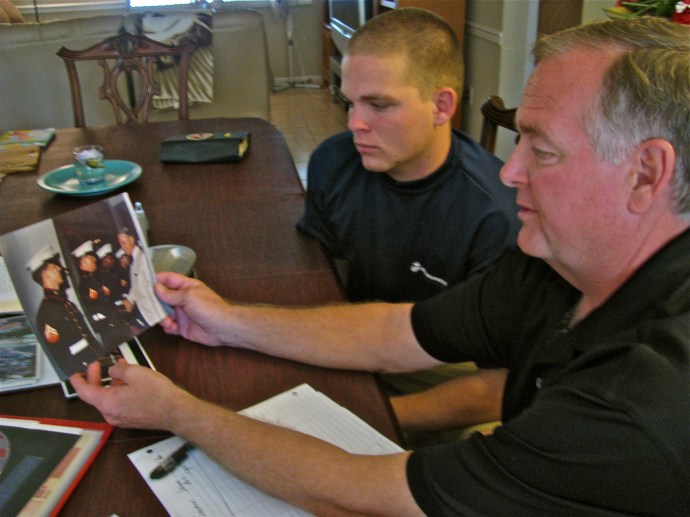 Randy and his son, Brett, look at old pictures from the father's tour in Vietnam almost 40 years ago. The photo shows Cpl. Smith, a Marine Corps guard at the American Embassy in Saigon, being greeted by Ambassador Graham Martin during the Marine Corps' birthday celebration on Nov. 19, 1974. Photo provided