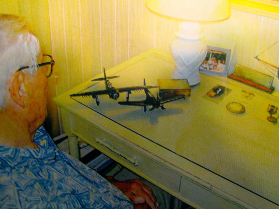 Bill Timmis of North Port, Fla. looks at some World War II model planes. One was of a Curtis Helldiver SB2 similar to the one he used to sink the Japanese battleship Hyuga. Sun photo by Don Moore