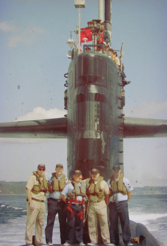 Sanzalone, fourth from the left, stands on the deck of the USS Pache (SSN-683) with a cigar in his mouth, along with the sub's officers after the attack submarine surfaced during sea trials off Bangor, Wash. in 2003. Photo provided