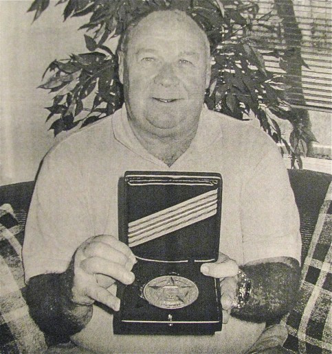 Tom Poole holds his massive "Intelligence Star" medal he received from the CIA for his outstanding work commanding three Thai mercenary battalions in the 1972 "Easter Offensive" during the "Secret War" in Laos. Sun photo by Don Moore