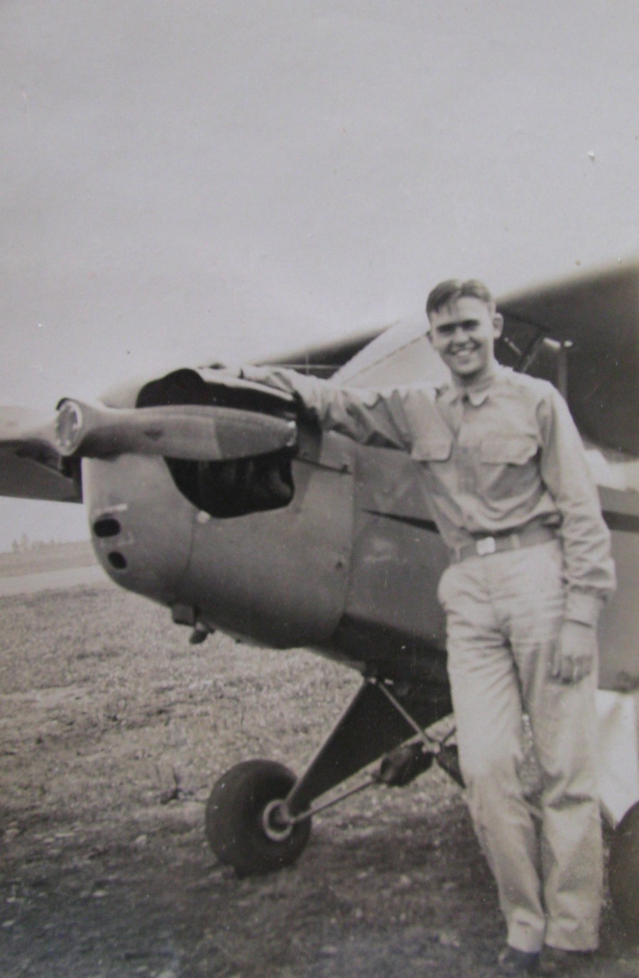 Cunningham is all smiles as he leans against a Piper Cub he soloed in during early flight training in the snow at Siena College in New York during the winter of 1942. Photo provided
