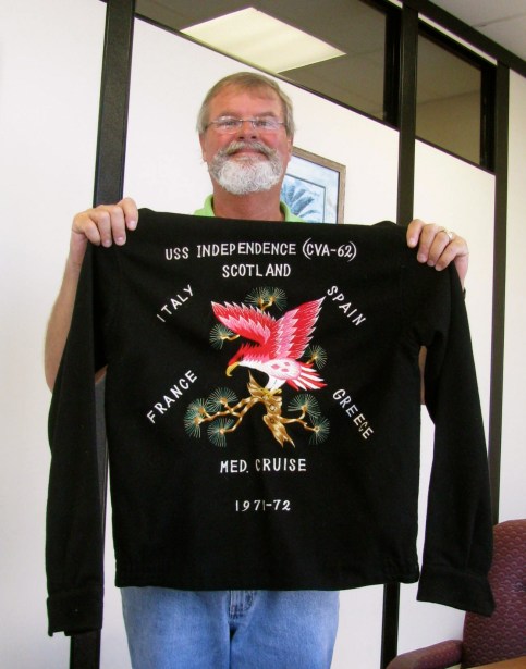 Holloway holds up a jacket made for him that lists some of the countries the Independence visited during his time aboard the carrier. Photo by Don Moore