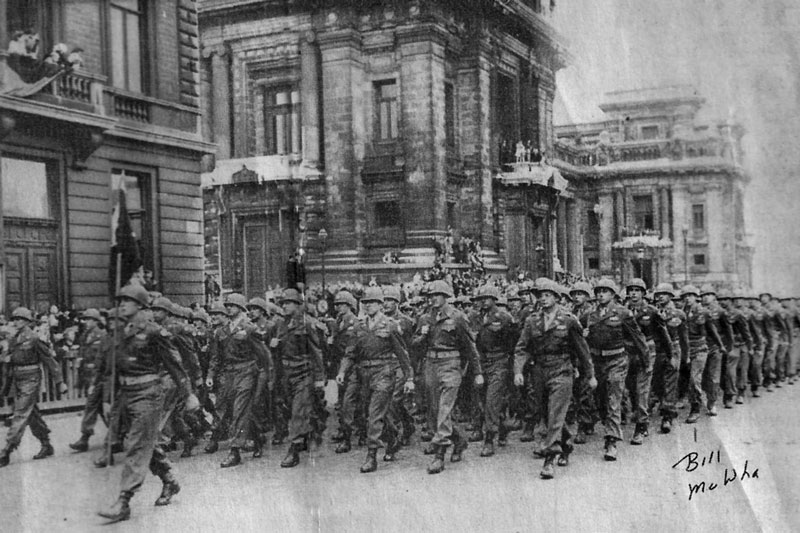 On parade: Soldiers in the 35th Infantry Division put on a parade in Belgium after the war for President Harry Truman. Pfc. William McWha of Englewood is in the middle of the line of marching soldiers on the end. The notation at the bottom of the picture points him out.