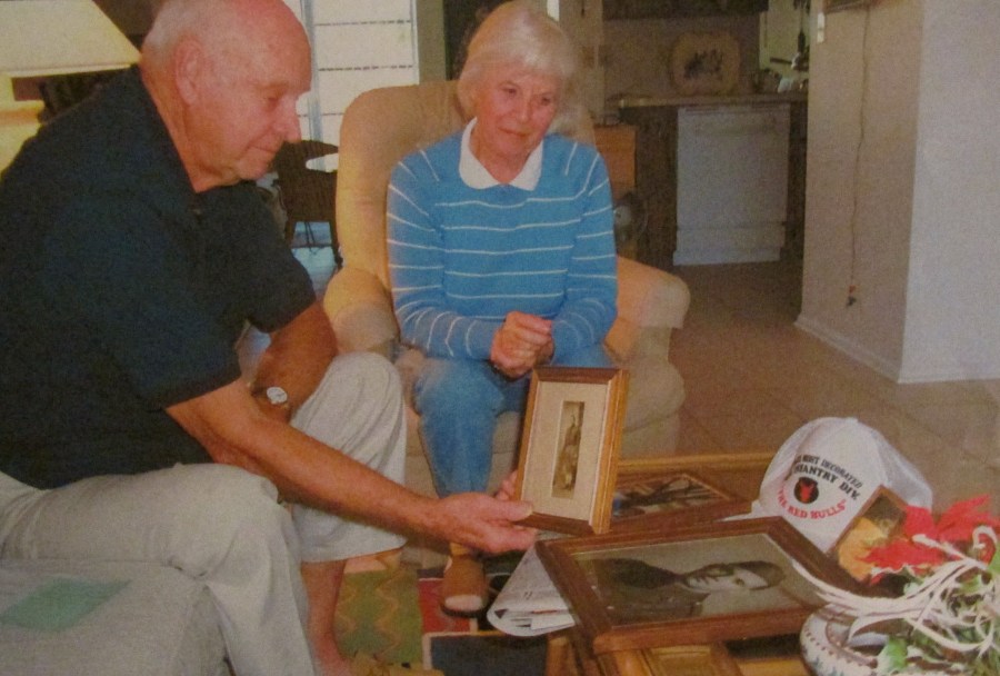 Jollay and his wife, Sammy, look at war photos of himself when he was a member of the 34th Infantry Division during World War II. Sun photo by Don Moore