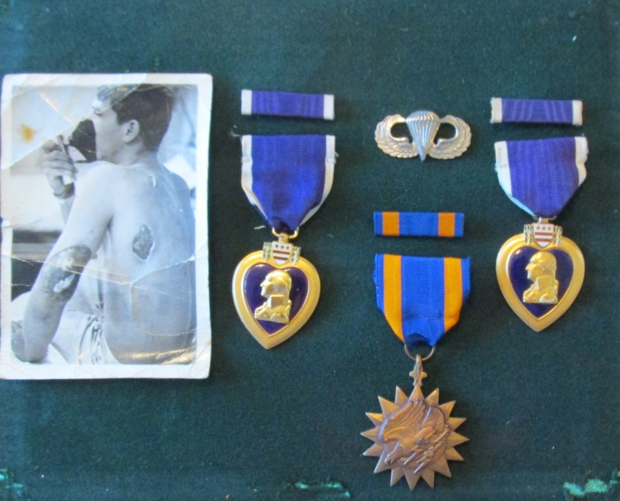 In a small shadow box on the same wall is a picture of Hirkey sitting on a hospital gurney with the bullet hole from a North Vietnam bullet plainly visible in his back an left arm. Two Purple Hearts, Airborne Wings, and the Air Medal are also displayed. Sun photo by Don Moore