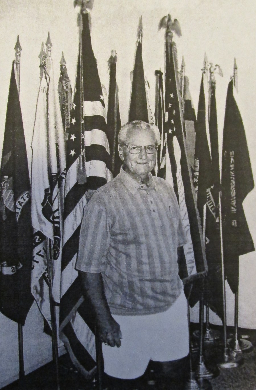 Jerry Meadows of Port Charlotte was a staff sergeant in the 106th Infantry Division. He was wounded and captured at St. Vicht, Belgium, during the Battle of the Bulge in World War II. He stands before  the flags at American Legion Post 110 of Port Charlotte's temporary headquarters, where he's post commander. Sun photo by Don Moore