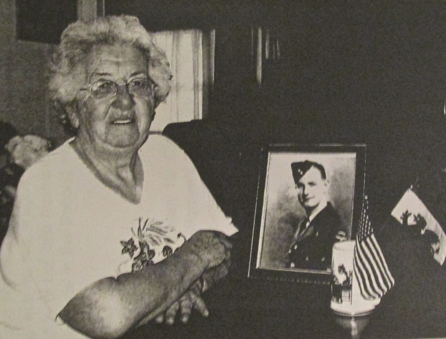 Elizabeth Adams of Harbor Cove in North Port was a WAAF in World War II. She installed radar in British Halifax bombers. She became an American citizen some years ago and keeps the small American flag to reminder her of the occasion. The Welsh flag with its red dragon reminds her of her homeland. The picture is of her late husband, Wing Cmdr. Allan Adams, a member of the Royal Canadian Air Force in the Second World War. Sun photo by Don Moore