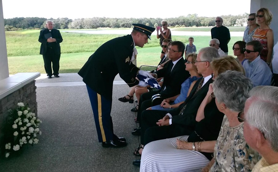 The corporal commanding the three-man honor guard at the Monday funeral of former Army Sgt. Walter Tatko of Venice at Sarasota National Cemetery present his son, Stanley, with his burial flag. In the foreground Leonard Tatko, the soldier’s younger brother, and other family members. Sun photo by Mary Auenson