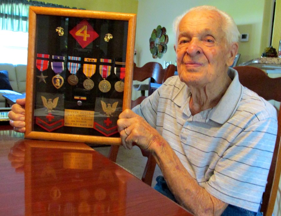 Bizeur holds a shadowbox of his World War II medals at his home in North Port. He received a Purple Heart, Bronze Star, Asiatic-Pacific Theatre Medal with three bronze battle starts, a Presidential Unit Citation, American Theater Medal, Occupation of Japan Medal and World War II Victory Medal. Sun photo by Do Moore