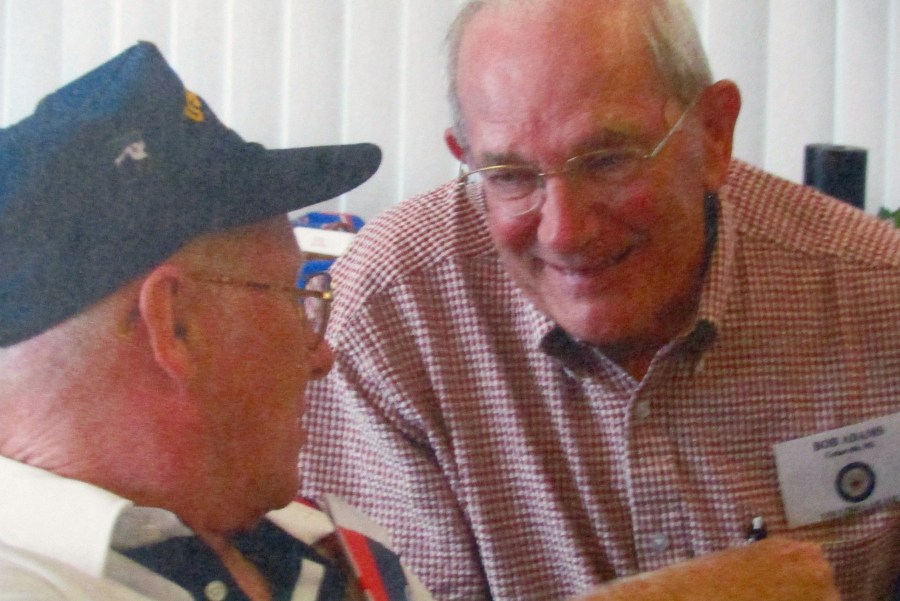 Adams talks with his best Navy buddy, Bob O’Brian, wearing his blue ball cap more than 50 years after they first met aboard the USS Libra during the Korean War. Photo provided