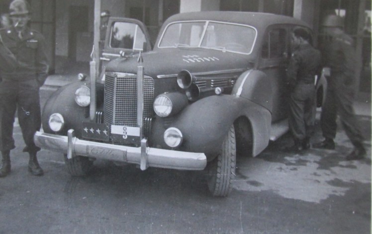 This is Patton’s 1938 Cadillac staff car parked on a street in Nuremberg. Note the tag on the front with Patton’s four star rank on the plate. Photo provided