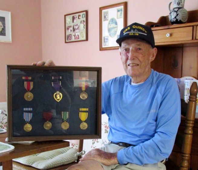 Cahill with a shadow box of World War II medals he received for his service during the Second Wold War. Sun photo by Don Moore