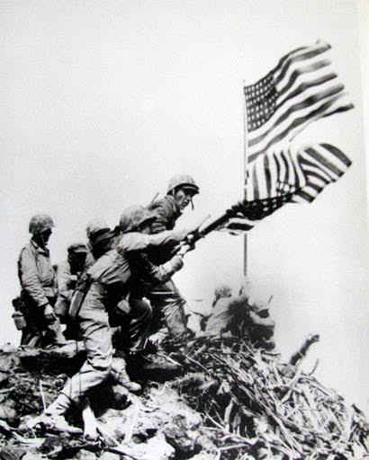 Marines put up the second American flag atop Mount Suribachi and take down the first flag on Feb. 23, 1945 during the Battle of Iwo Jima near the end of World War II. Photo provided by Dick Honyak
